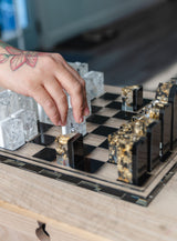 A hand moving a chess piece on a resin chess board set crafted using the mold from Modern Mold's Games & Hobbies collection.