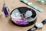 Jewellery sitting in a dish with a preserved orchid, beside a ring holder, both created using molds from the Modern Mold Jewellery Holders collection.