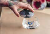 A hand removing the lid off of a faceted trinket dish, created using a mold from Modern Mold's Jewellery Holders collection.