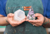 Melissa, founder of Modern Mold, holding a mold and the resulting resin art for a ring holder.