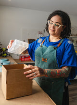 Melissa, founder of Modern Mold, placing a mold in a box for shipping.